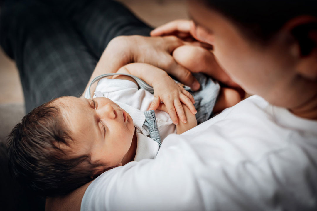 Vater hält Baby im Arm Babyfotos Bielefeld Fotograf