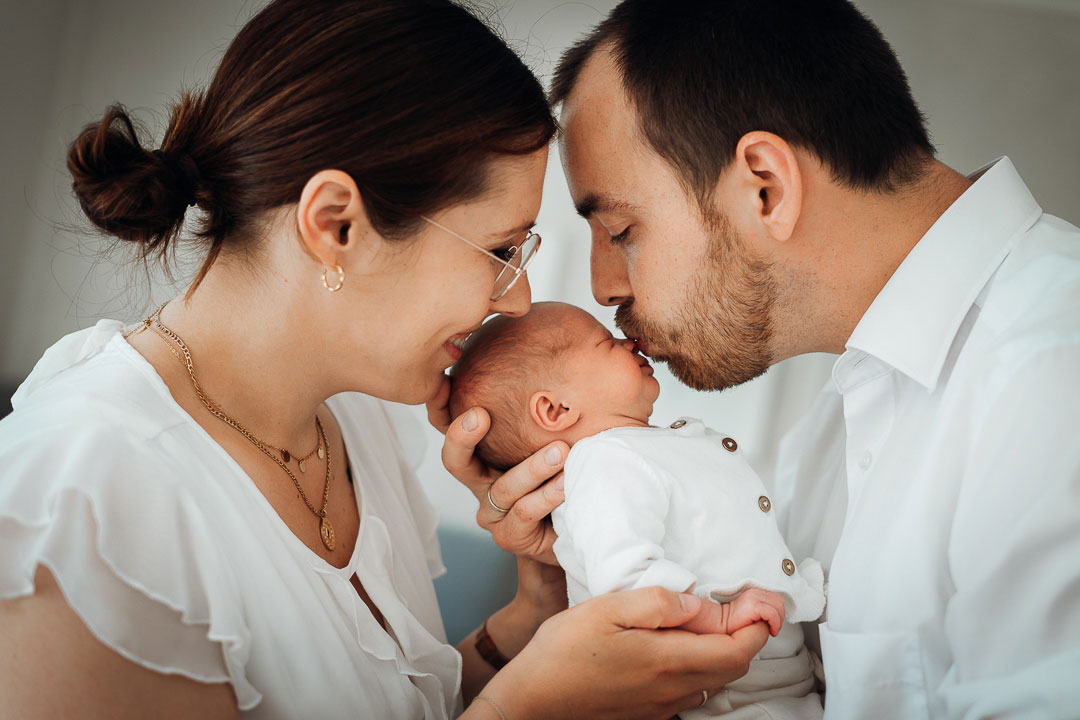 Papa und Mama küssen Baby Babyfotos Bielefeld Fotograf