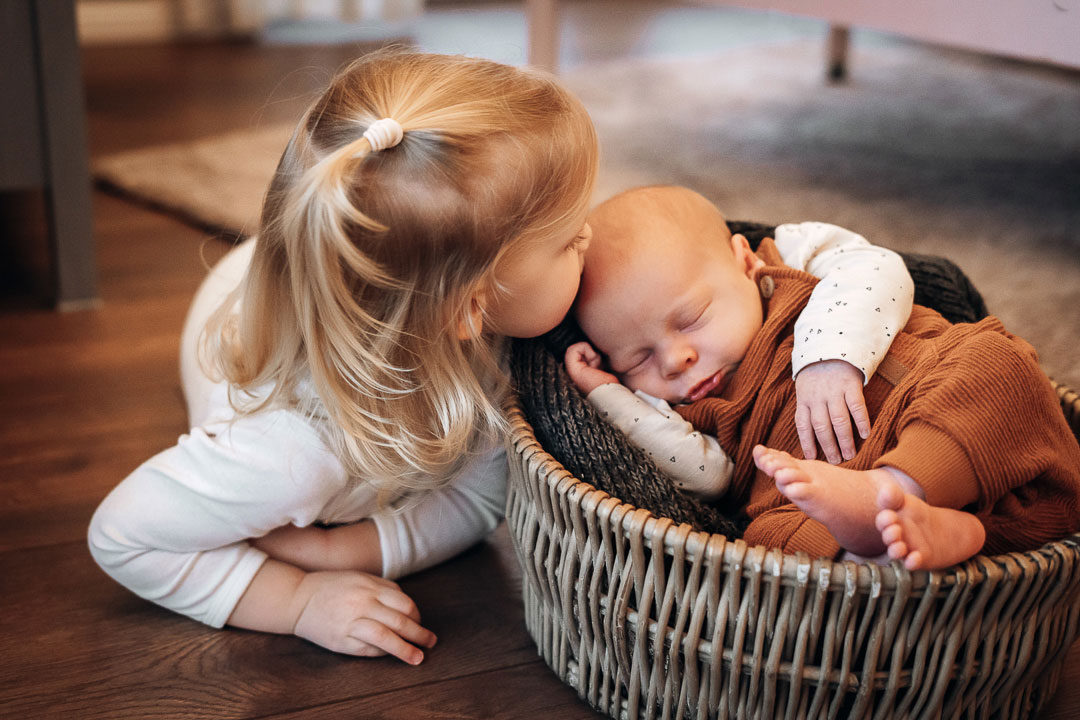 Schwester küsst Baby Babyfotos Bielefeld Fotograf