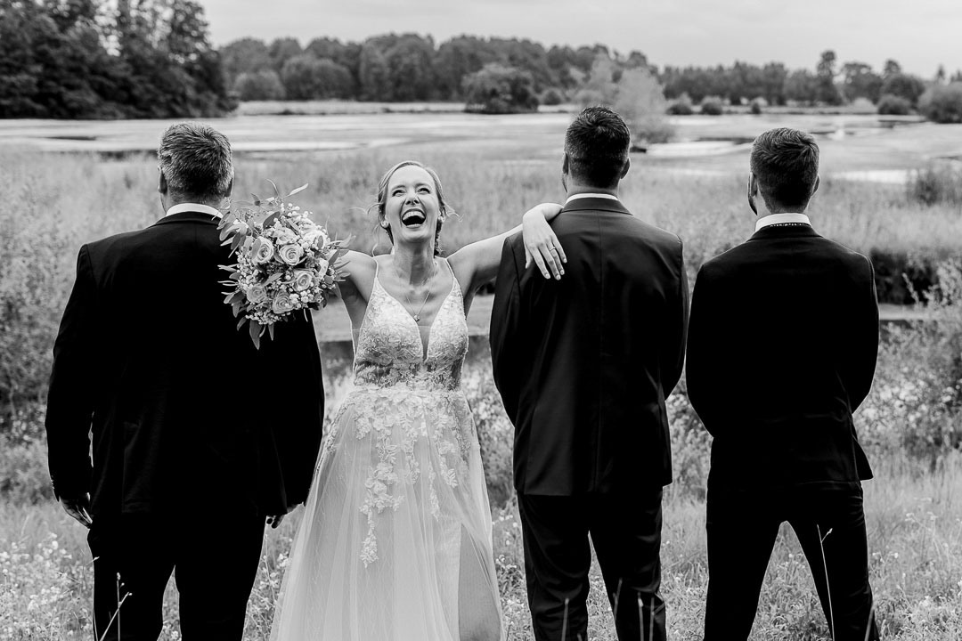 Braut lacht SW mit Ehemann und Trauzeugen